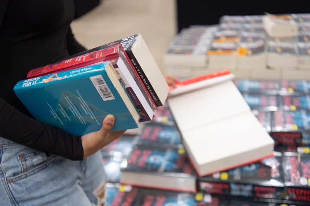 a woman buying a couple of books in a book sale