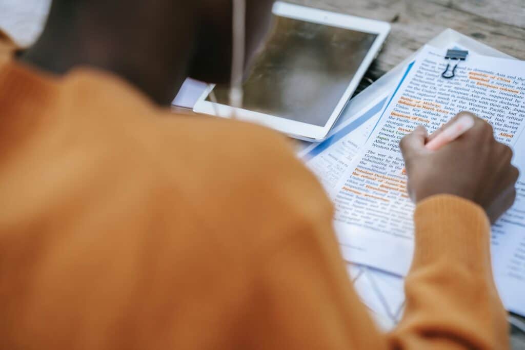 a man doing research and highlighting words in an article