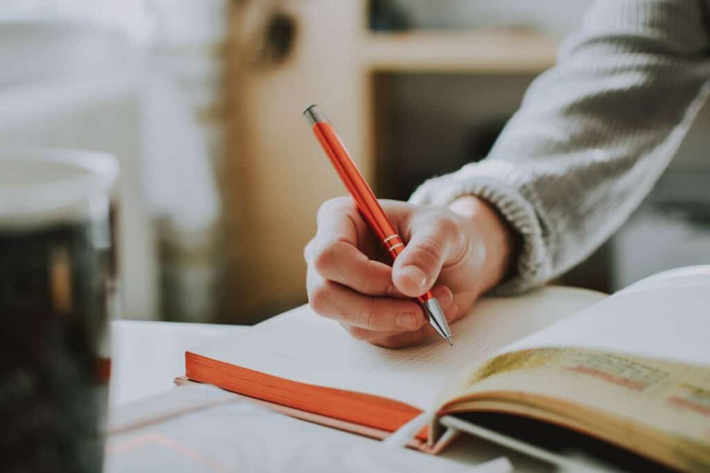 person writing on an empty notebook page