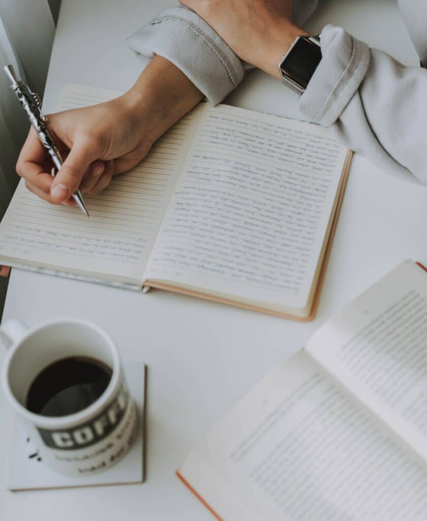 someone with a coffee cup and a book outline in the background